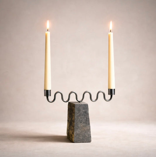Candle holder with two lit candles on a neutral background